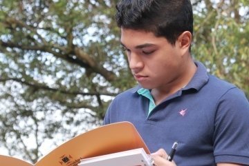 Joven leyendo en carpeta UPB