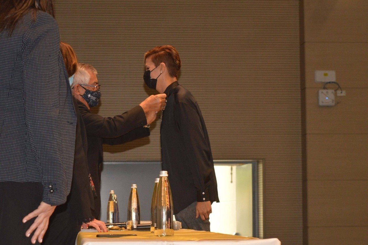 Imposición del escudo de la UPB a Lina Escobar por parte del señor Rector General, Pbro. Julio Jairo Ceballos.