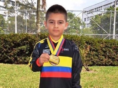 El estudiante posa con el uniforme deportivo y luce la medalla