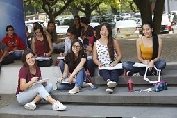 Estudiantes sentadas en la carpa tarima de la UPB