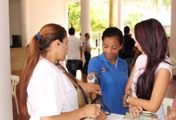 Enfermera tomando la presión a estudiantes