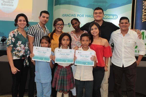 Los tres ganadores del concurso junto a la docente Luisana Riveira y los estudiantes de Comunicación Social - Periodismo, gestores de la actividad.