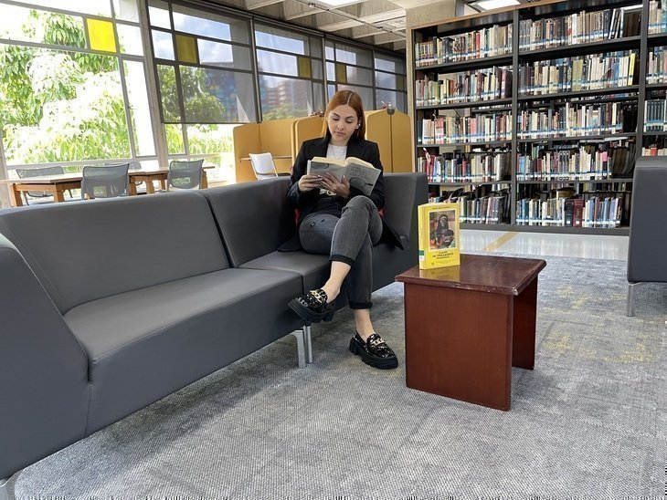 Mujer leyendo en la Biblioteca Central UPB