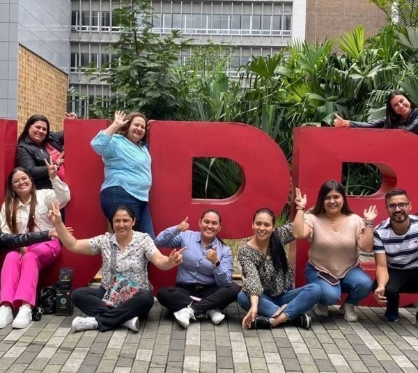 Estudiantes ubicados alrededor de letras grandes en rojo de la UPB