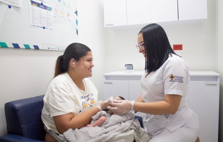 Estudiantes de Enfermería UPB atendiendo a madre con bebe en consultorio médico